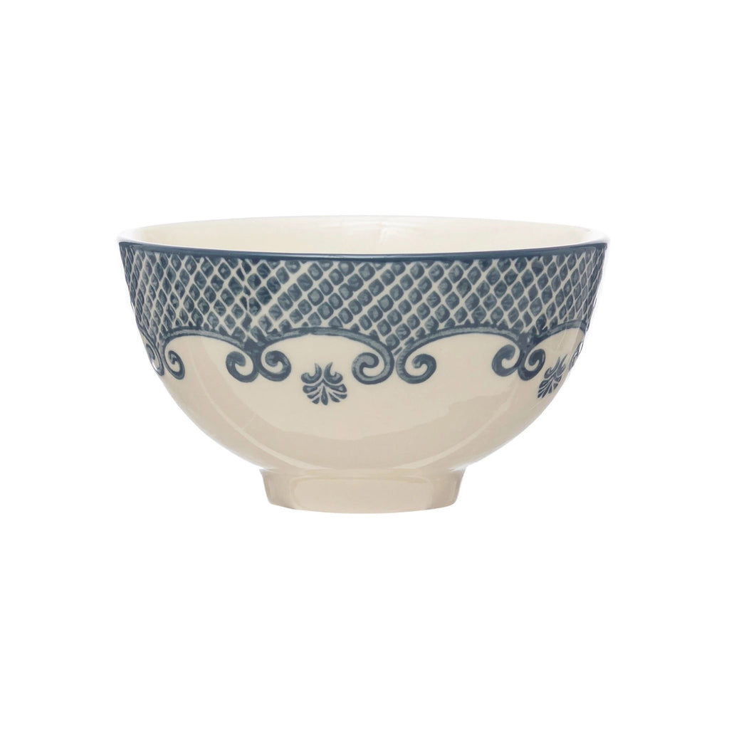 Creative Co-op Round Hand-Stamped Footed Bowl with blue pattern on cream backdrop, side view.