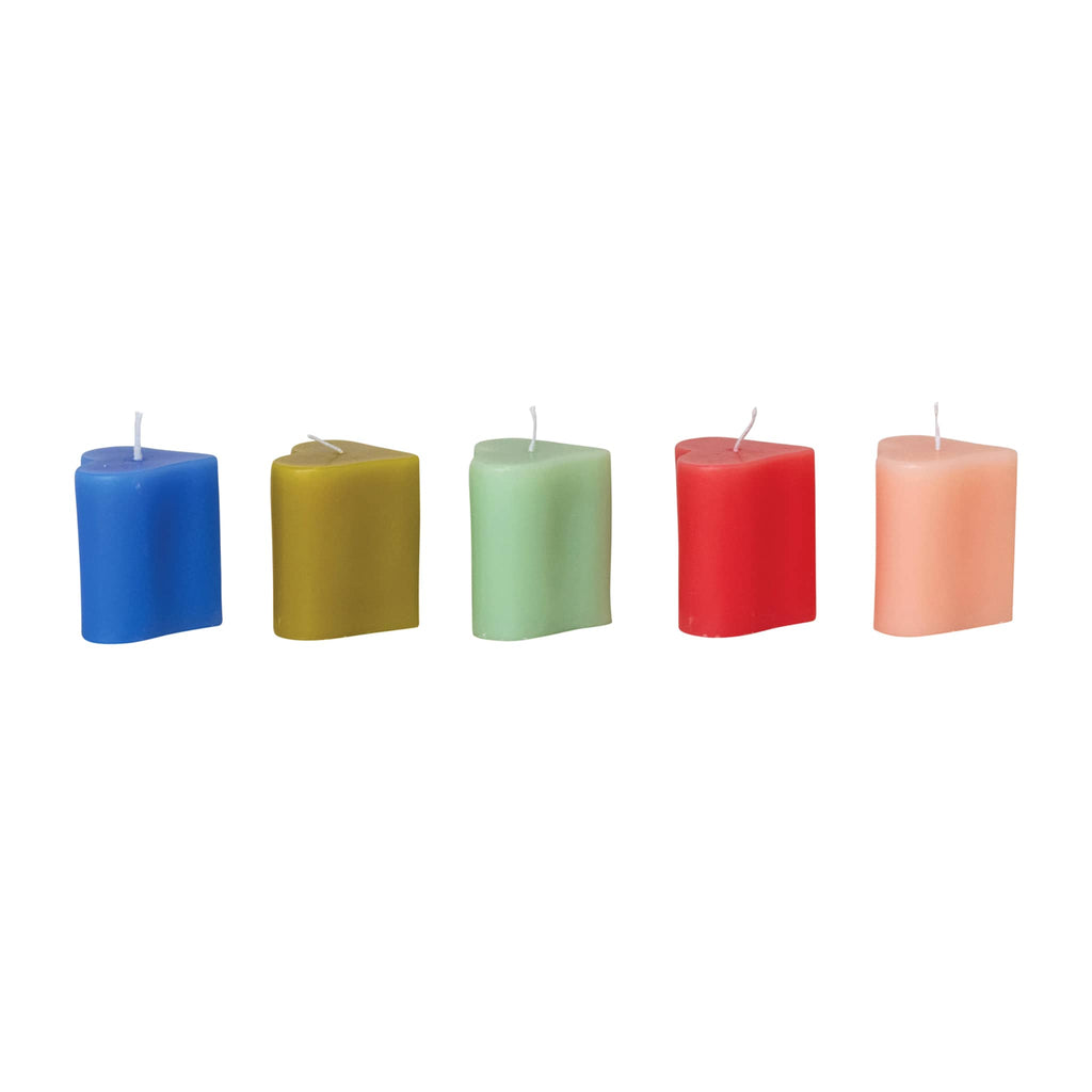 Five colorful heart shaped candles on a white background.