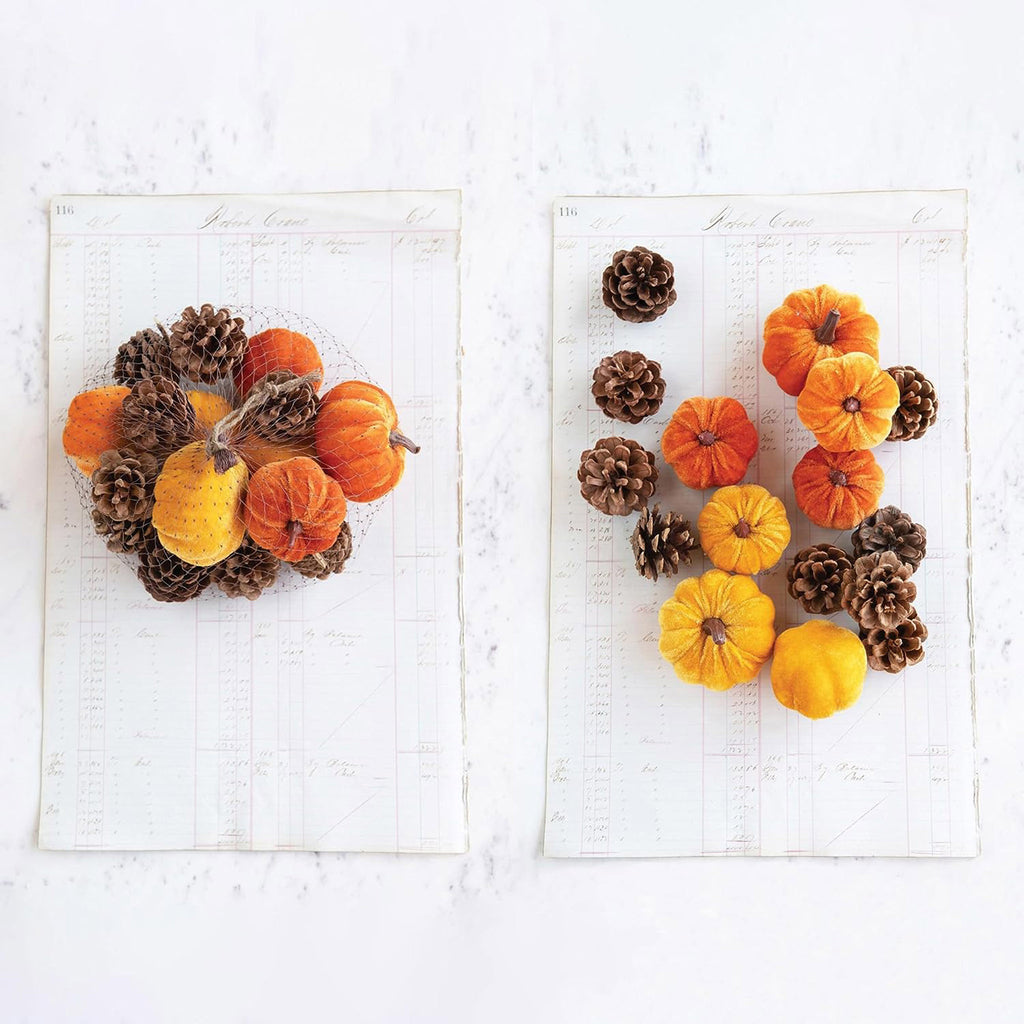 Creative Co-op Velvet Pumpkins and natural dried pinecones in a mesh bag and scattered in a lifestyle photo.