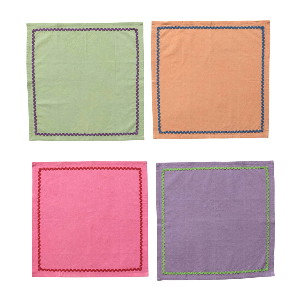 Creative Co-op square cotton napkins in purple, pink, orange and green with contrasting ric rac trim, set of four, flat.