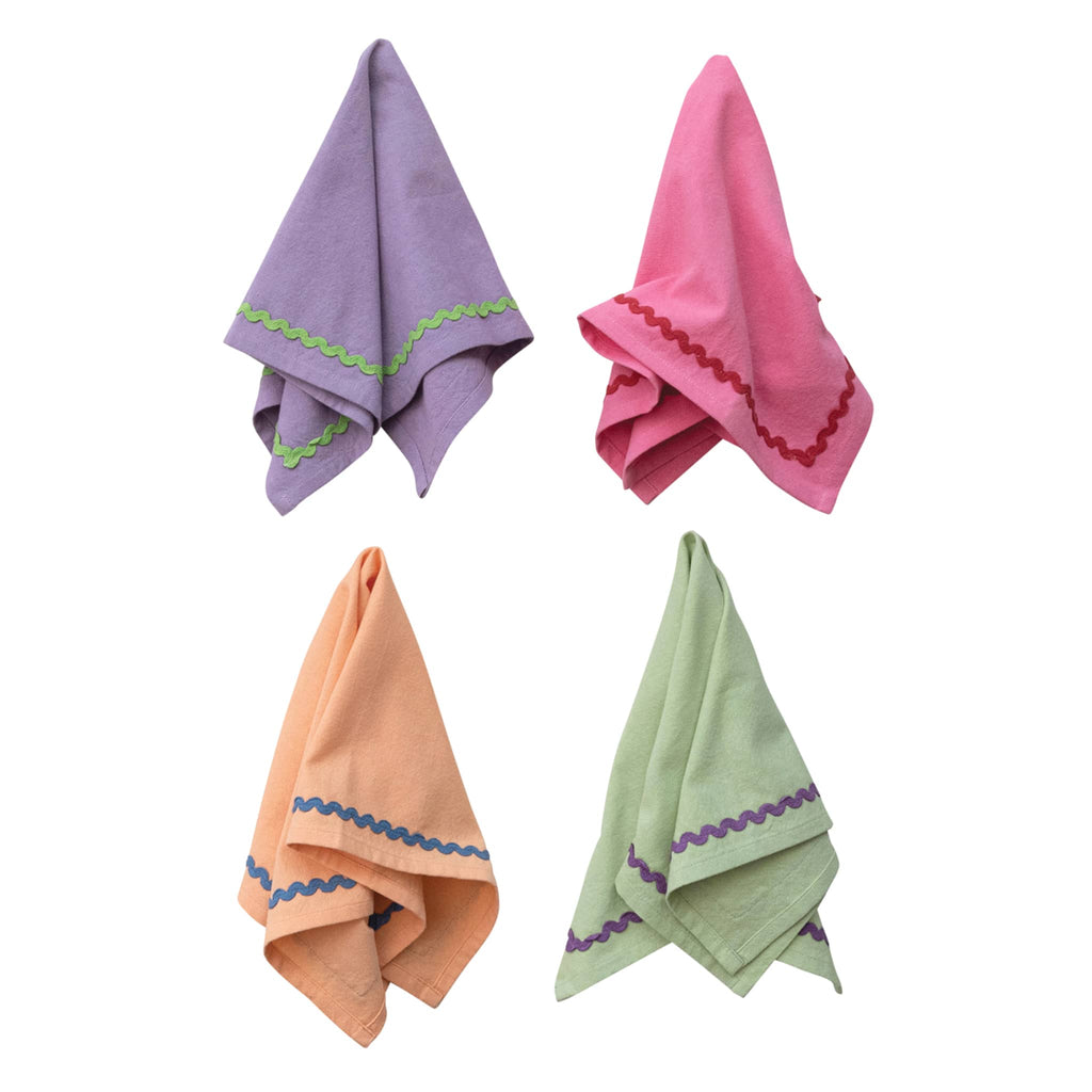 Creative Co-op square cotton napkins in purple, pink, orange and green with contrasting ric rac trim, set of four, hanging.