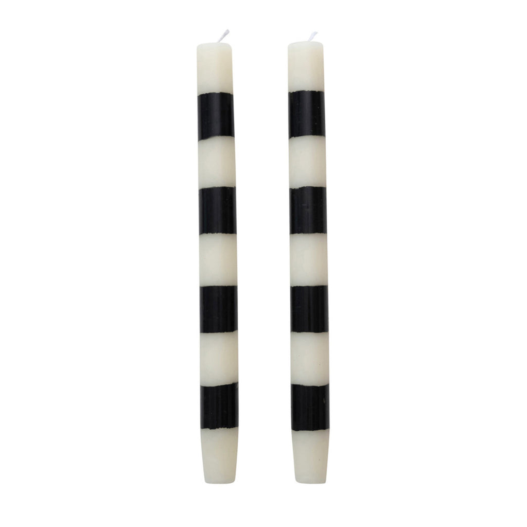 Two black and white striped taper candles on a white background.