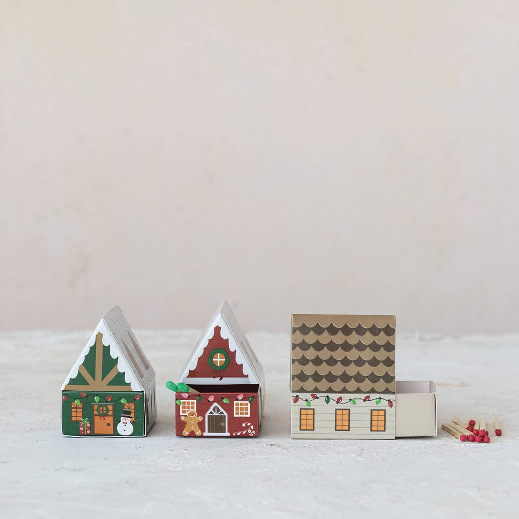 Set of decorative house-shaped matchboxes on a light background.