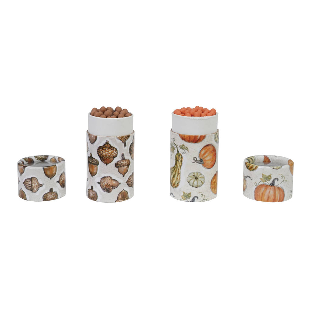 Set of two decorative tubes with autumn-themed patterns and matches on a white background.