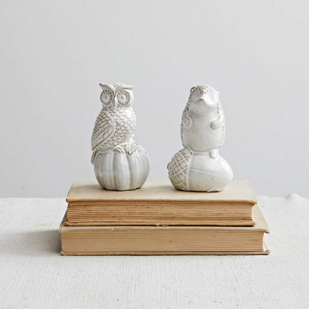 Creative Co-op stoneware owl sitting on a pumpkin and hedgehog on an acorn  figurines with cream reactive glaze, sitting on a pair of books.