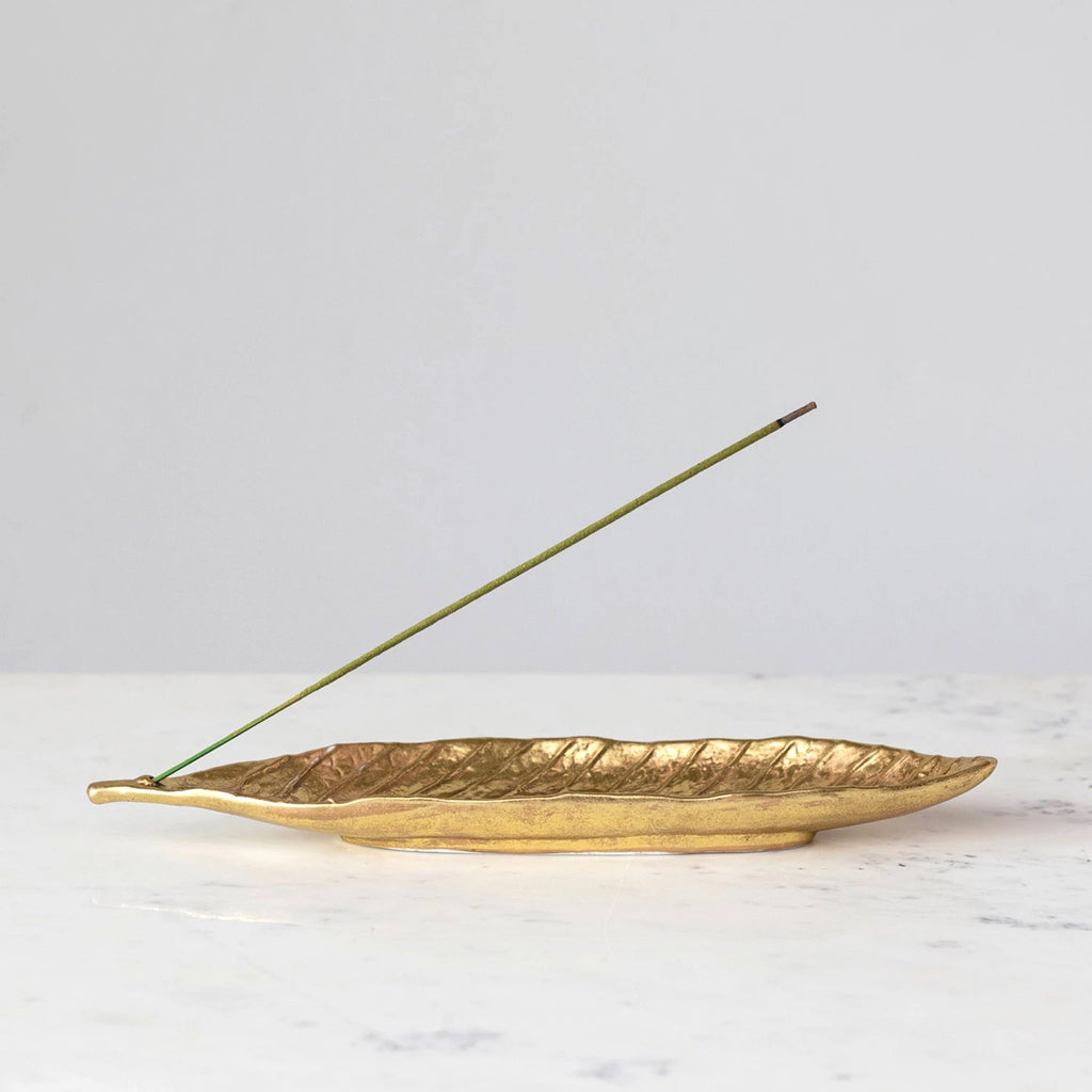 Creative Co-op embossed stoneware leaf-shaped incense holder with gold electroplating, with incense stick.