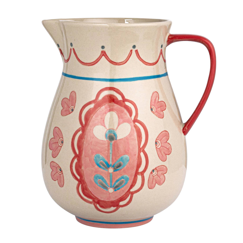 Creative Co-op Hand-Painted Floral Stoneware Pitcher with red handle on the right.