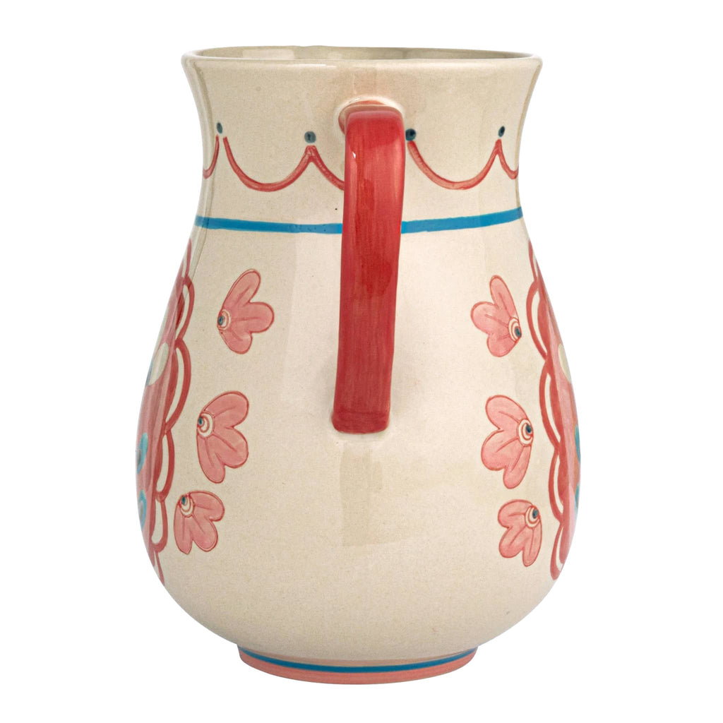 Creative Co-op Hand-Painted Floral Stoneware Pitcher with red handle, side view.