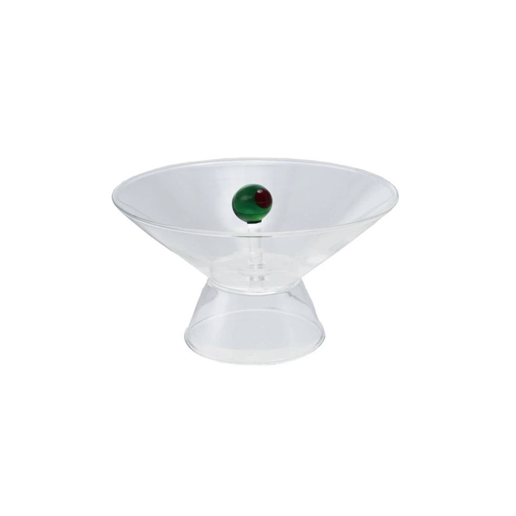 Clear glass footed serving bowl with a glass green olive in middle, on a white background.
