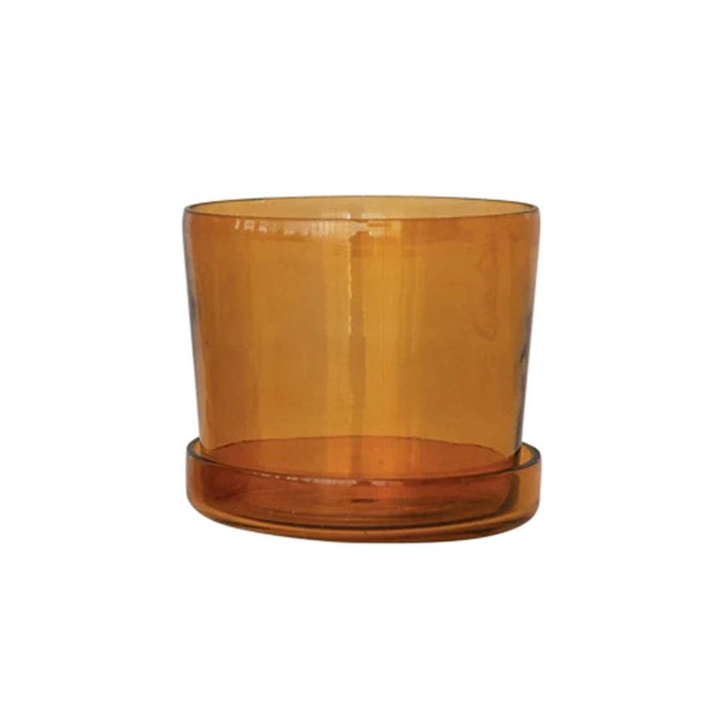 Amber glass planter with saucer on a white background.