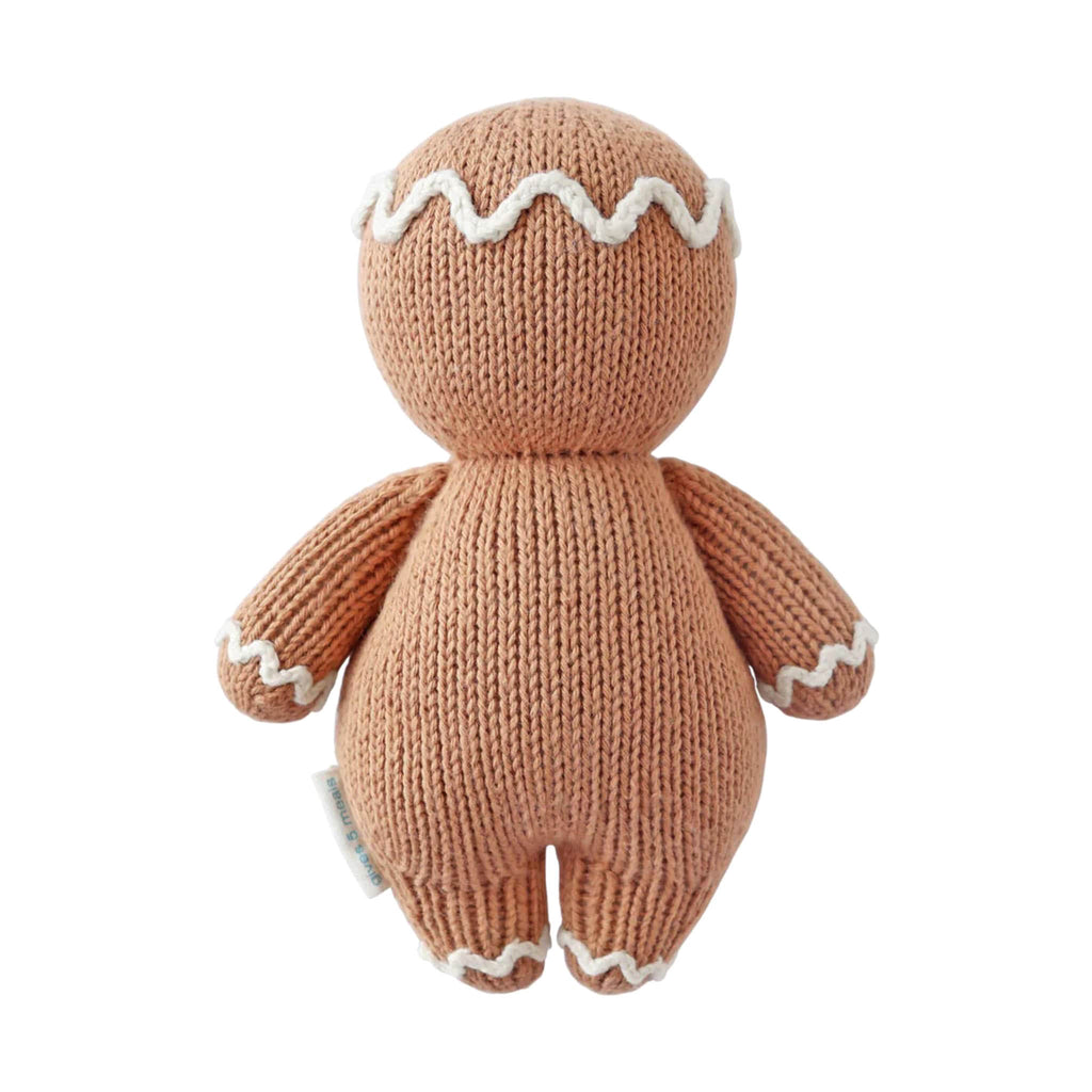 Knitted gingerbread person toy, back view, on a white background.