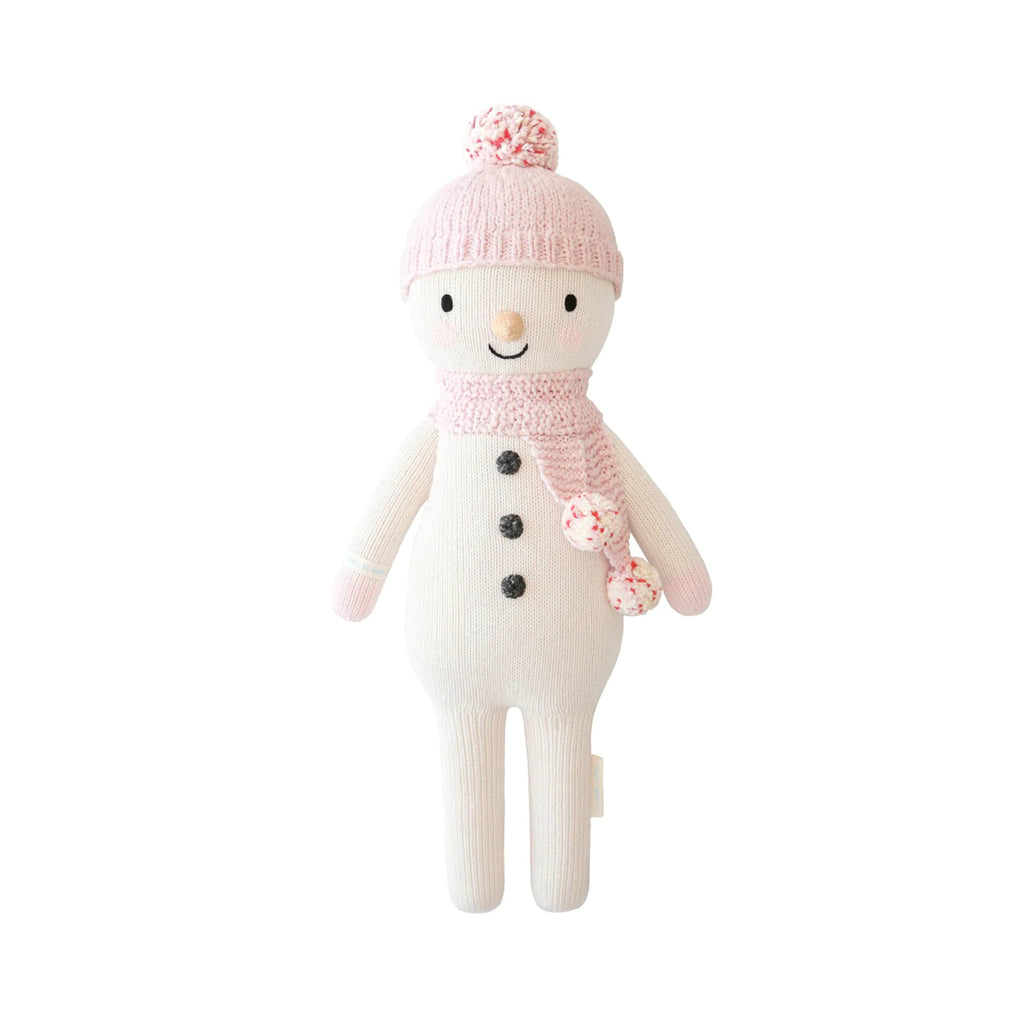 White snowman knit toy with pink hat and scarf on a white background.
