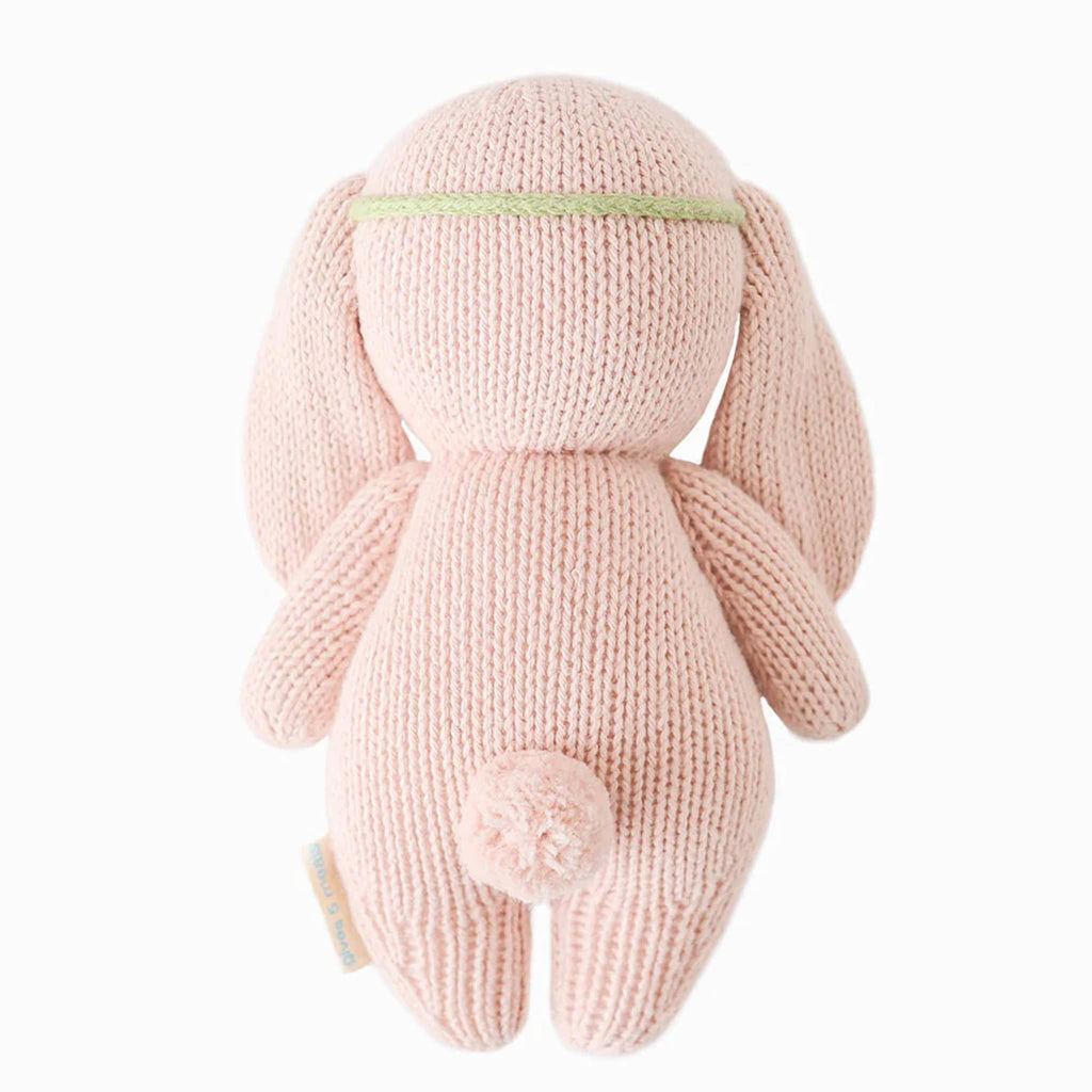 Cuddle and Kind Baby Bunny rose with ivory floral headband, hand knit doll, back view.