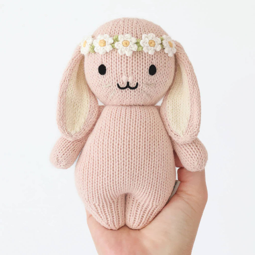 Cuddle and Kind Baby Bunny rose with ivory floral headband, hand knit doll, front view in hand.