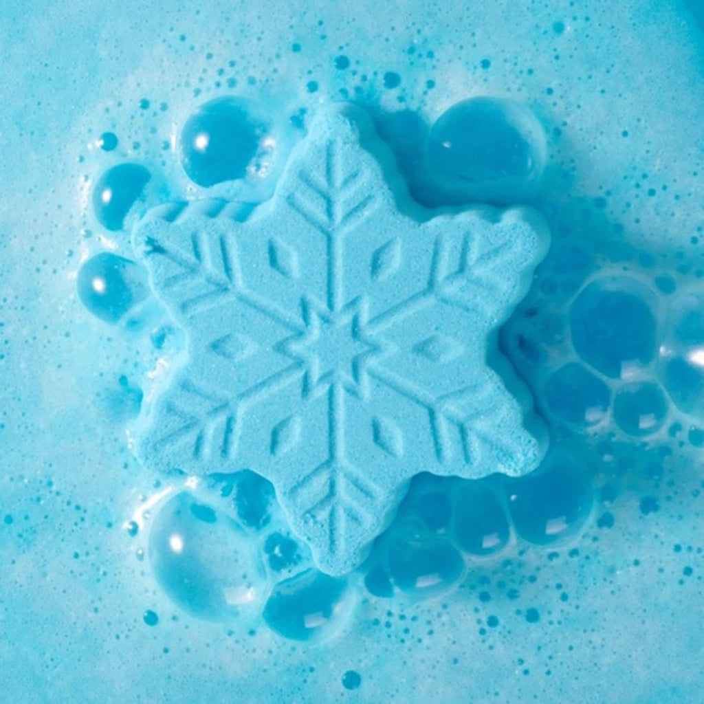 Blue snowflake-shaped bath bomb with bubbles on a blue background.