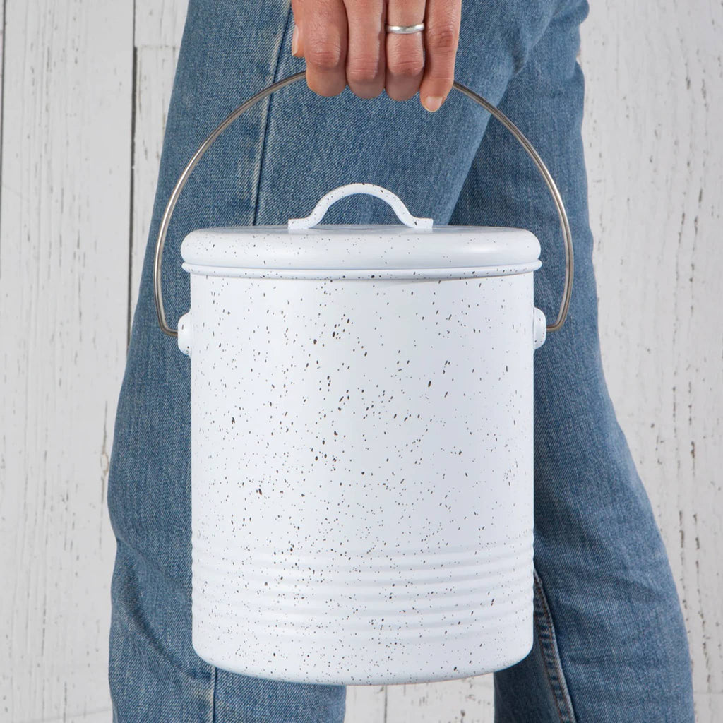 Danica Metal Compost Bin in white with gray speckles, being carried by the built-in handle.