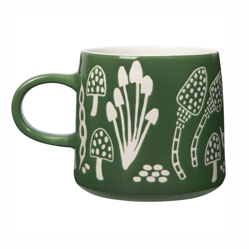 Green mug with white fungi wax-resist patterns on a white background.