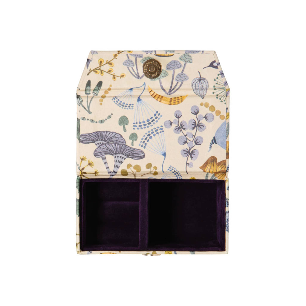 Rectangular travel jewelry box with mushroom pattern, lid open with purple velvet lining on the inside, on a white background.