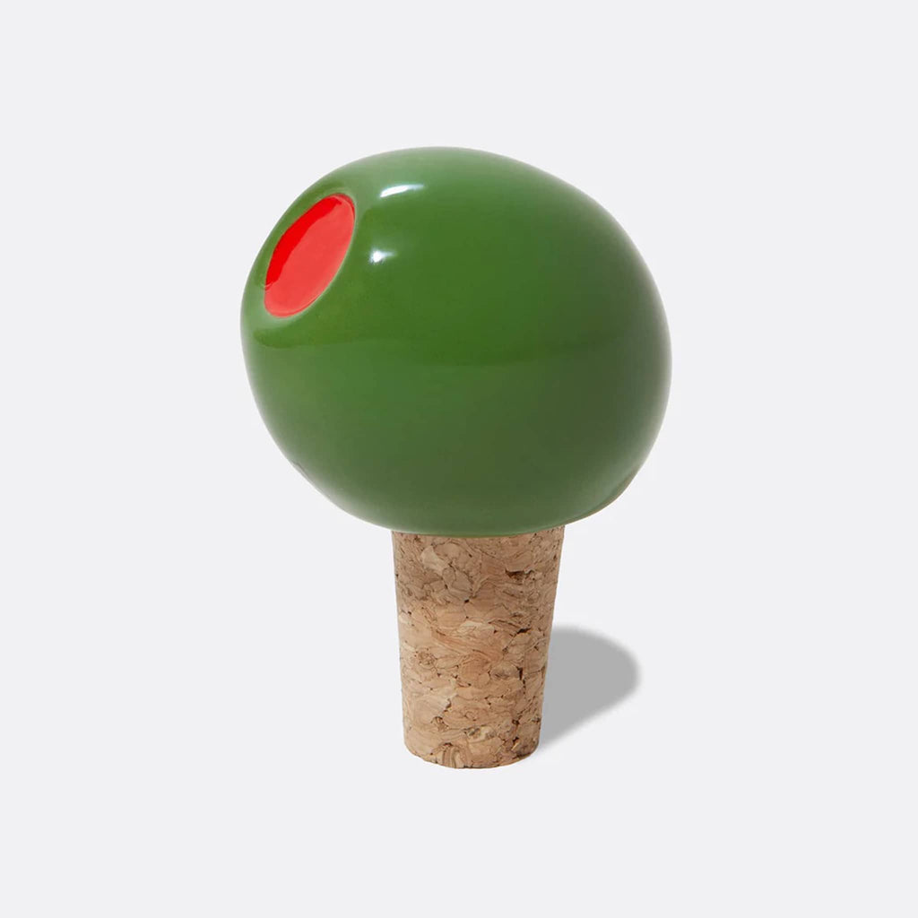Ceramic green olive bottle stopper with cork base on a white background.