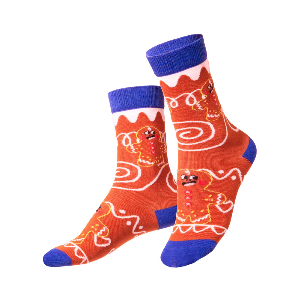 Pair of red socks with blue accents and gingerbread man design on a white background.
