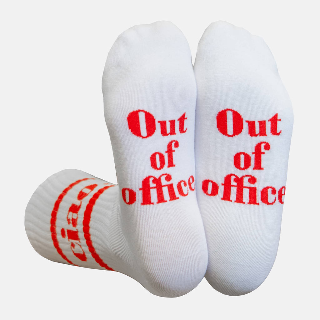 White crew socks with red text 'Out of office' on the sole, on a white background.