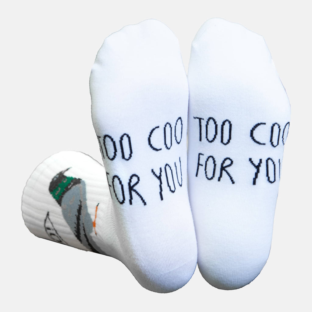 White socks with 'Too Coo For You' text on the soles, on a light gray background.