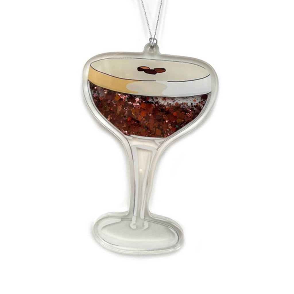 Decorative acrylic ornament shaped like a coupe glass with brown glittery liquid on a white background.