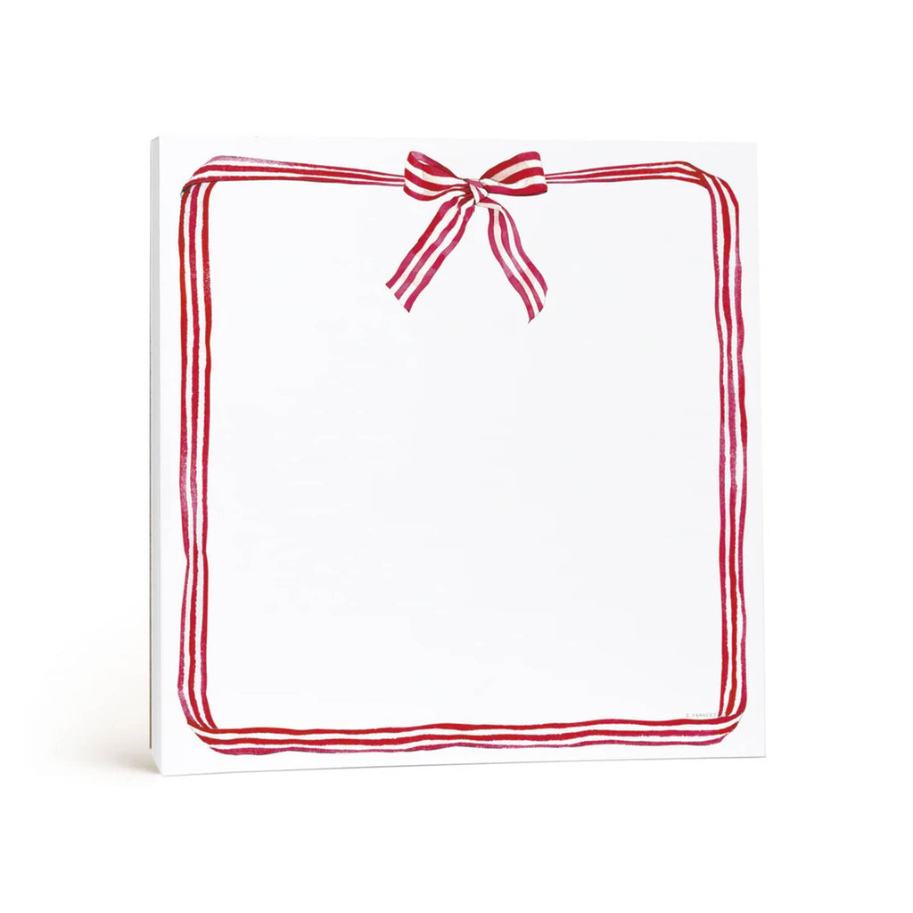 White paper notepad with red and white ribbon border and bow in the middle at the top, on a white background.