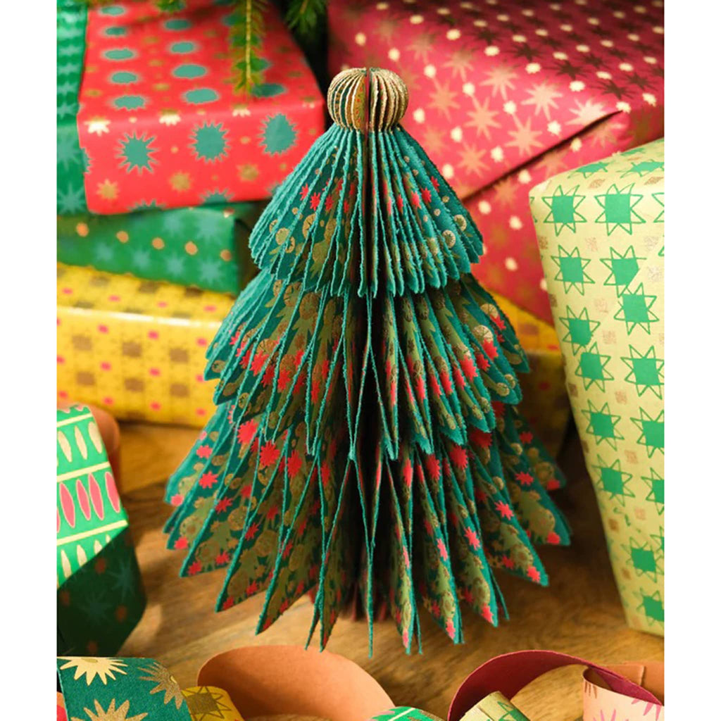 Decorative paper Christmas tree with colorful gift wrapped boxes in the background.
