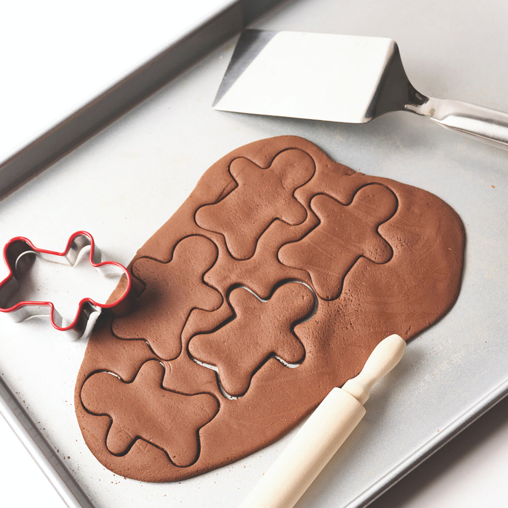 Eco Kids Gingerbread Ornament Kit, dough rolled out and cut into gingerbread men shapes.
