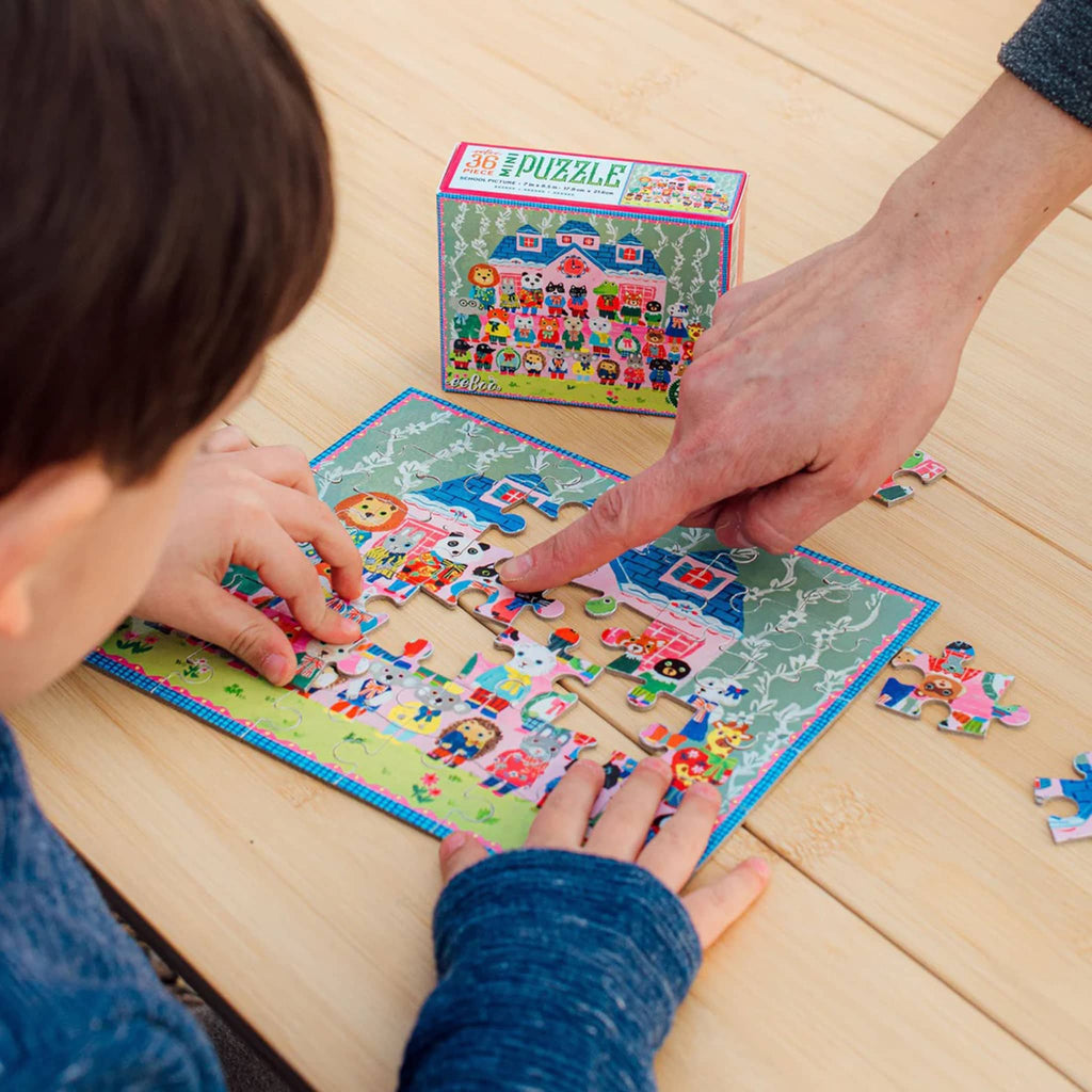 Child and adult working on a colorful puzzle together on a wooden table.