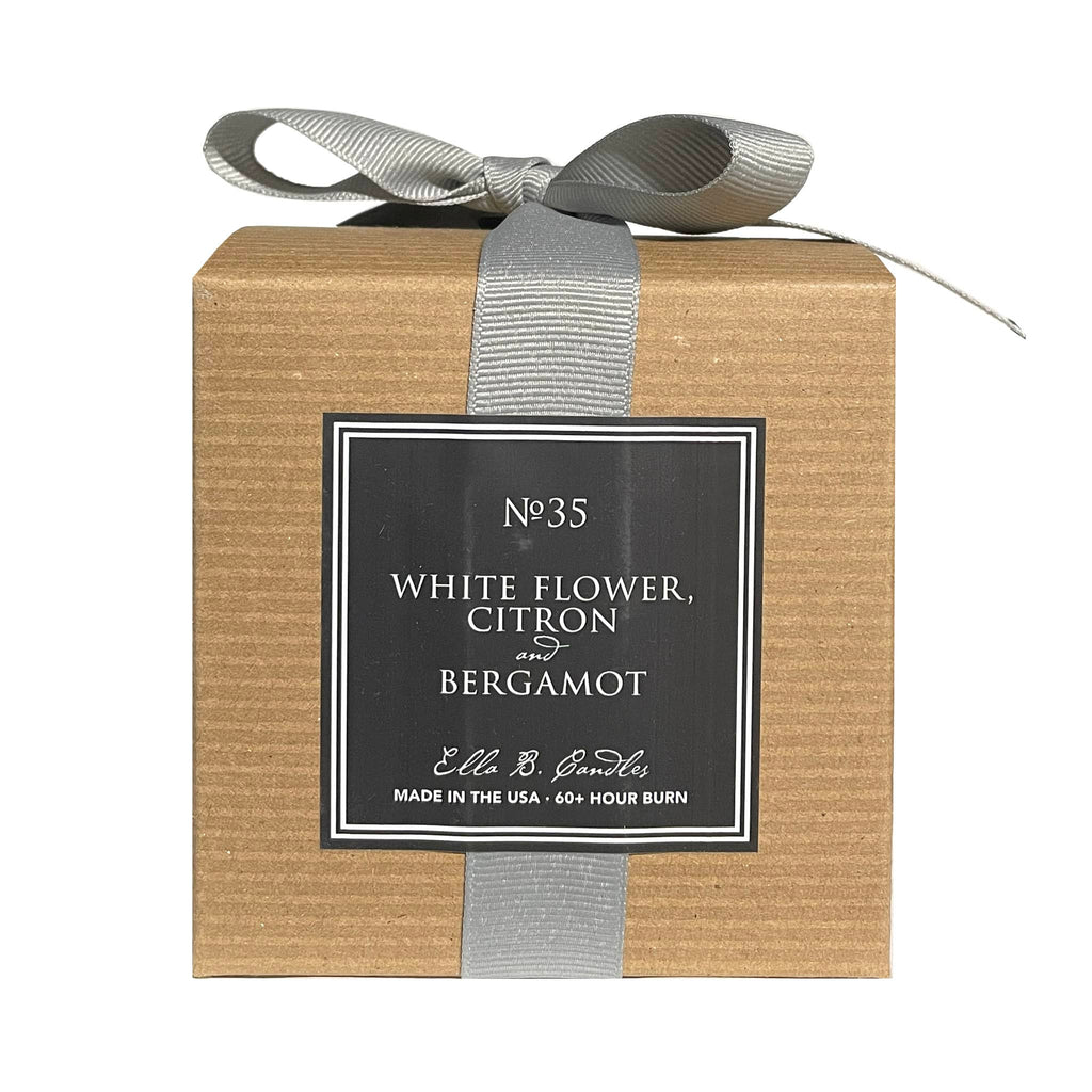 Ella B Candles "A Toast to the Host" white flower, citron and bergamot scented soy wax candle in brown kraft paper box with gray grosgrain ribbon, back view.