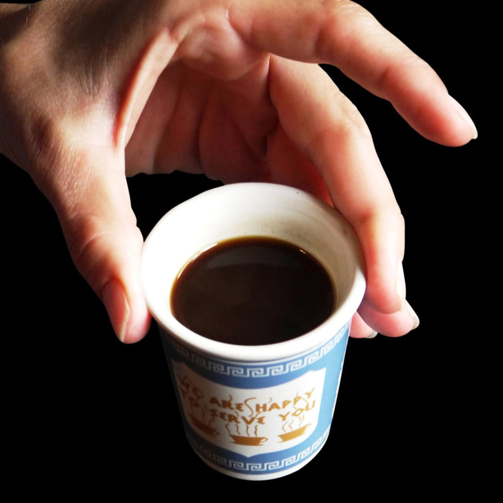 Exception Labs 3 ounce greek ceramic espresso deli cup with espresso in it being held by fingers for scale.