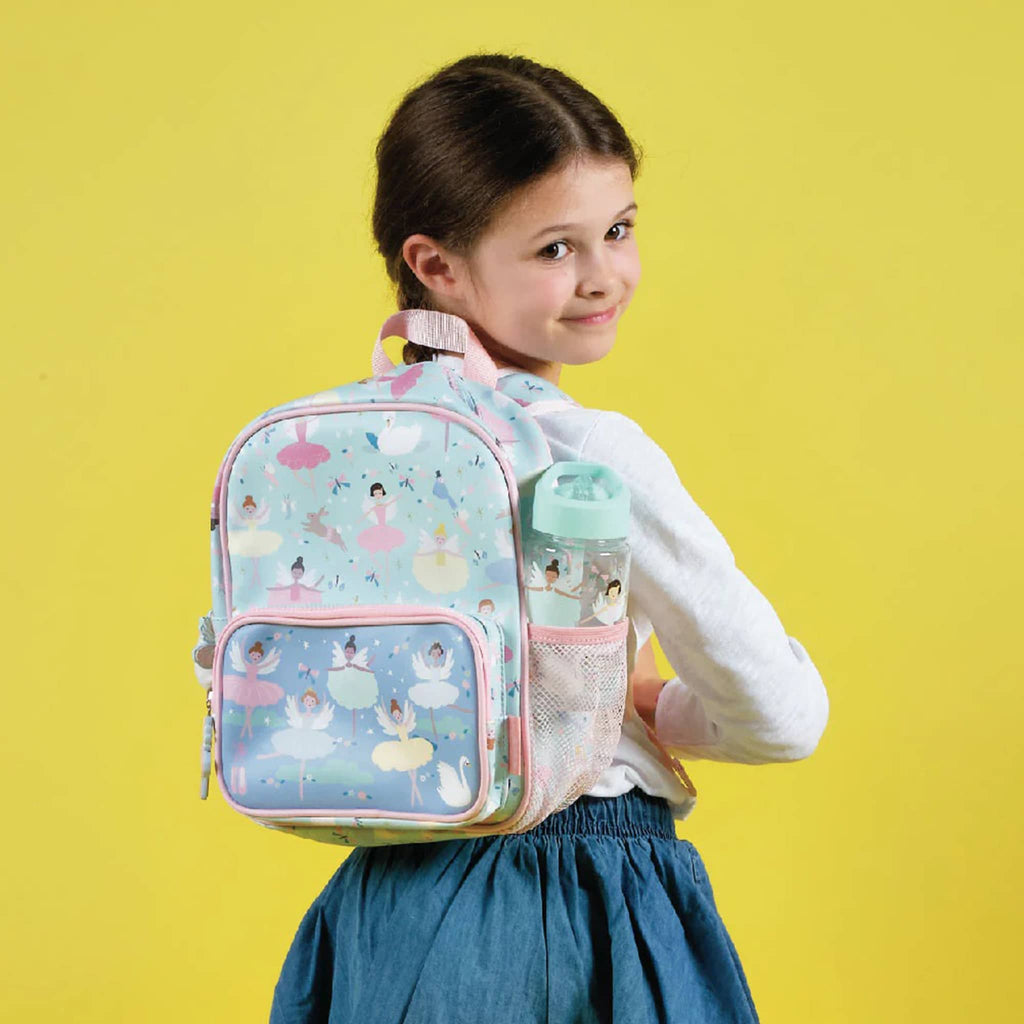 Floss and Rock Enchanted print on pale blue backpack, shown on a child's back with a water bottle in mesh pocket.