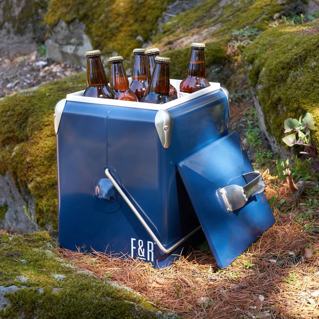 Foster and Rye Vintage Blue Stainless Steel Cooler with handle, open with bottles inside in outdoor setting.