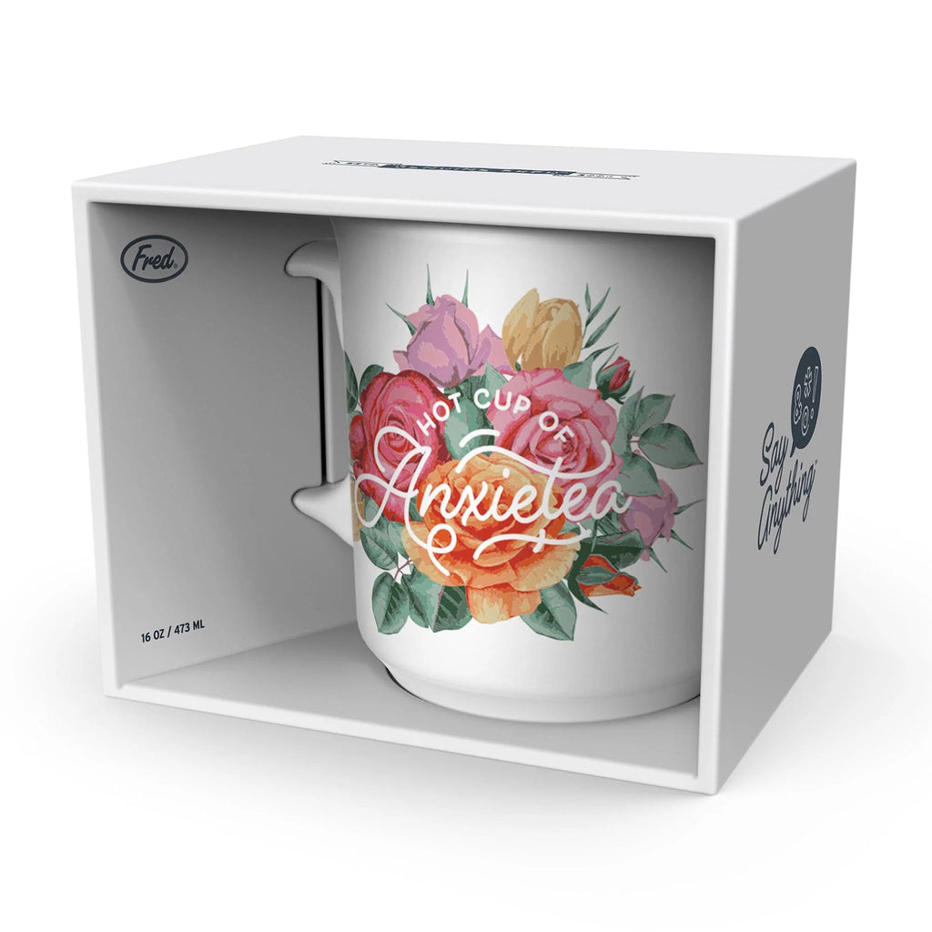 Genuine Fred white ceramic mug with "hot cup of anxietea" and colorful rose illustration, in box packaging.