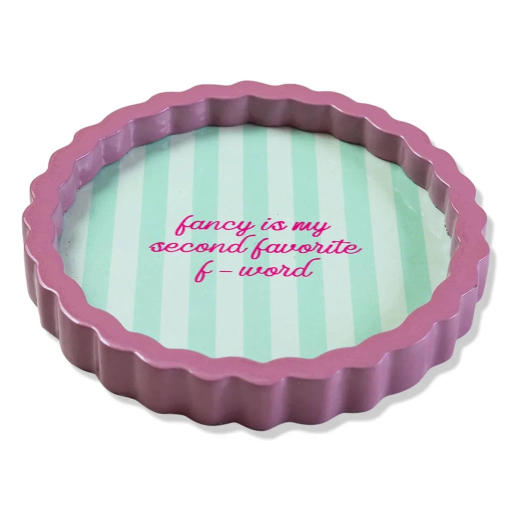 Round decorative lacquer tray with pink wavy rim and green striped background with "fancy is my second favorite f-word", on a white background, side view.