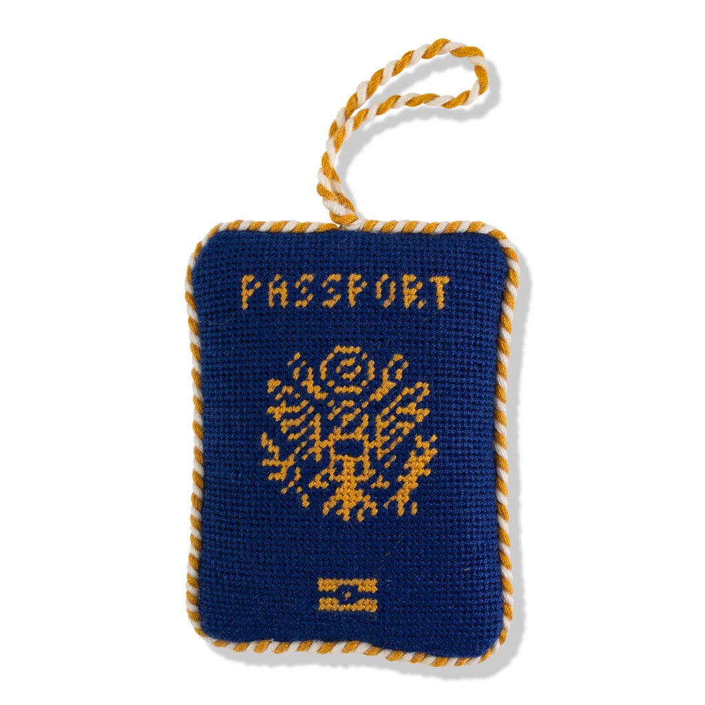 Blue and yellow passport-shaped needlepoint ornament with a hanging loop on a white background.