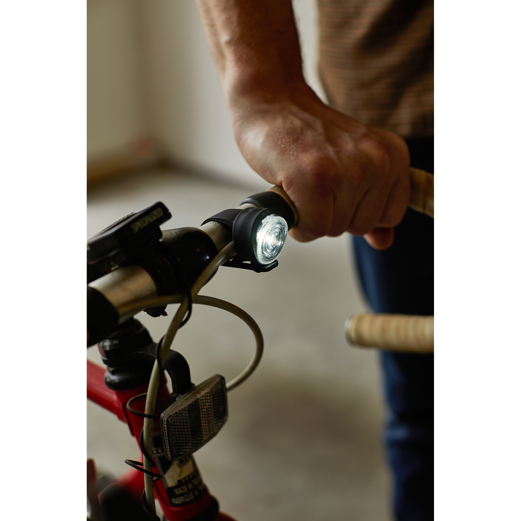Gentlemen's Hardware Twin Bicycle Lights, white light shown on the front of a bike, lit.