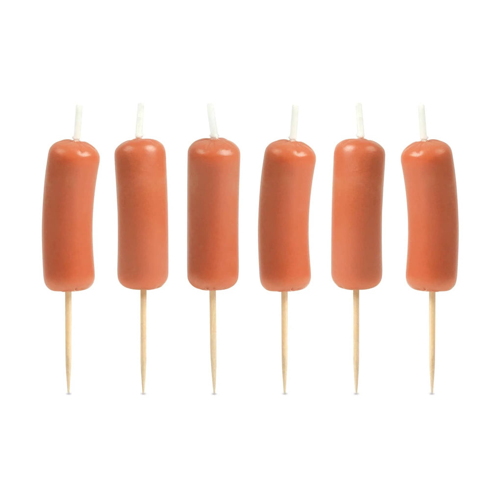 Six sausage wax candles on toothpicks arranged in a row on a white background.