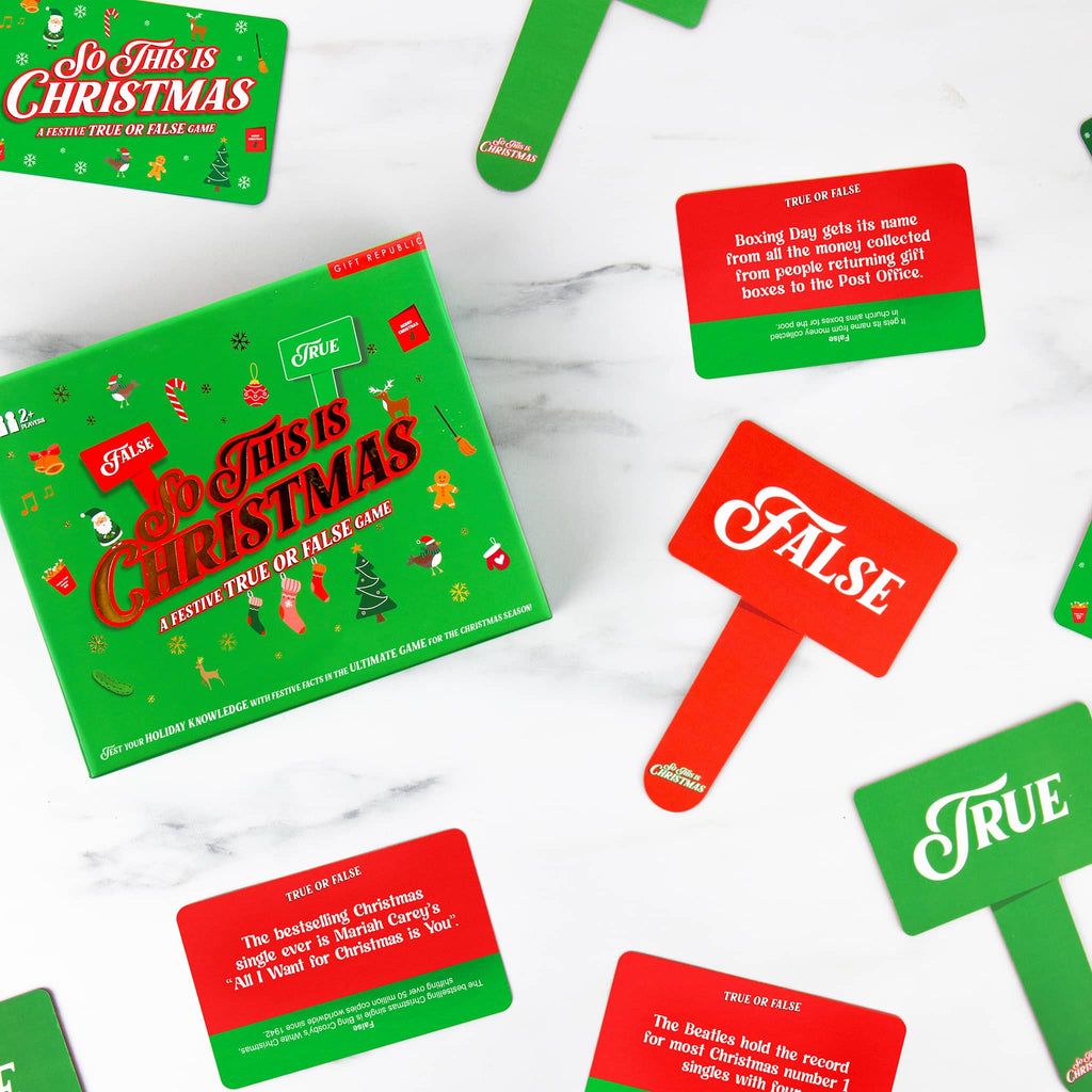 Christmas-themed game box with 'True' and 'False' cards on a white marble surface.