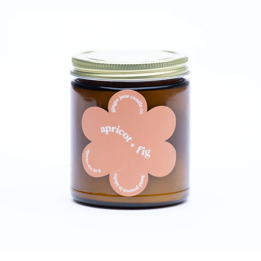 Ginger June 9 ounce Apricot and Fig scented soy wax candle in amber jar with gold screw-on lid and daisy-shaped peach label.