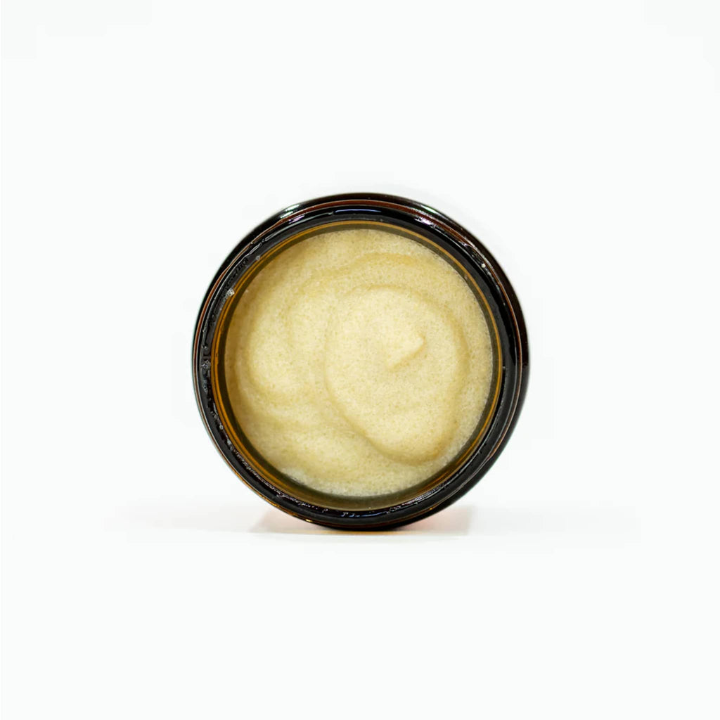 Ginger June Daydream Body Polish in amber jar, lying down with cap off to show contents.