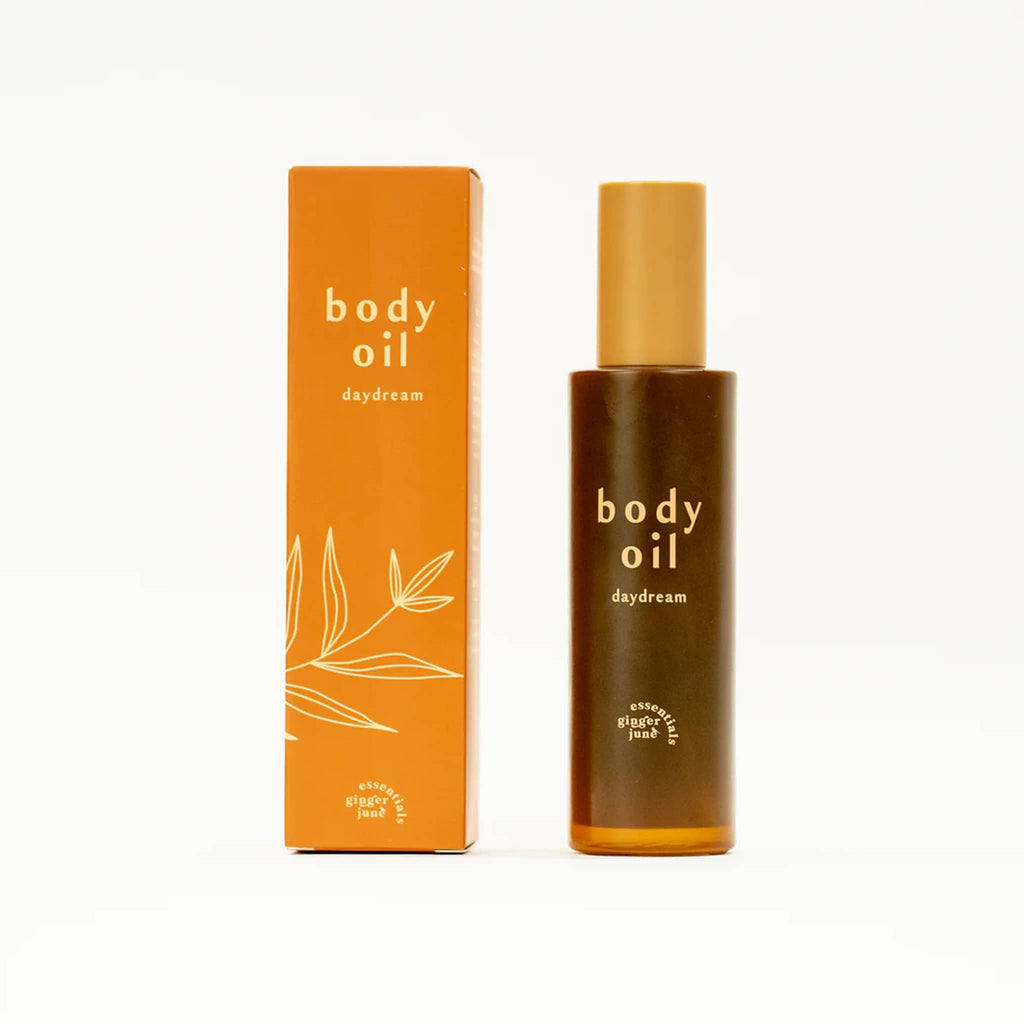 Ginger June Daydream scented body oil in bottle beside orange gift box.