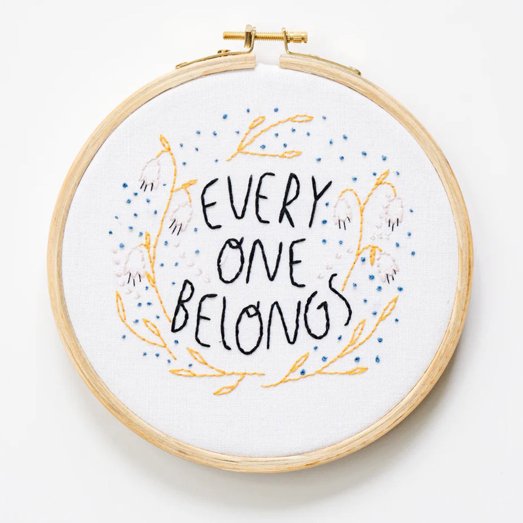 Gingiber Everyone Belongs Embroidery Kit finished hoop with embroidered floral design and "Everyone Belongs" in black lettering.