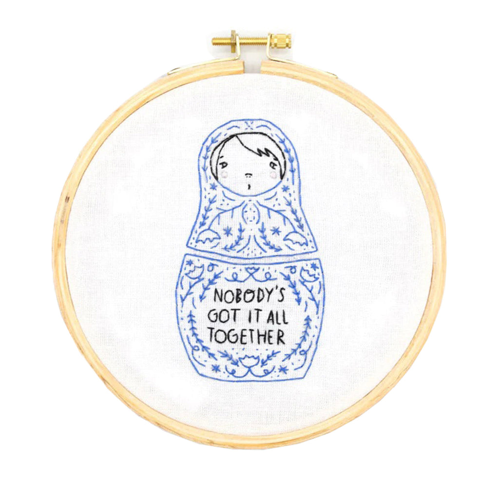 Gingiber Embroidery Kit finished hoop with embroidered matryoshka doll design and "Nobody's Got it All Together" in black lettering.