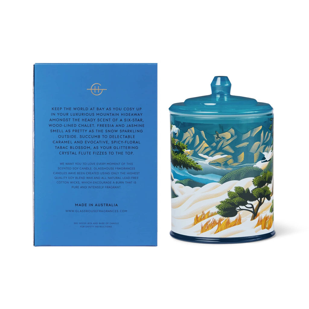 Candle jar with scenic design next to a blue box with information, on a white background.