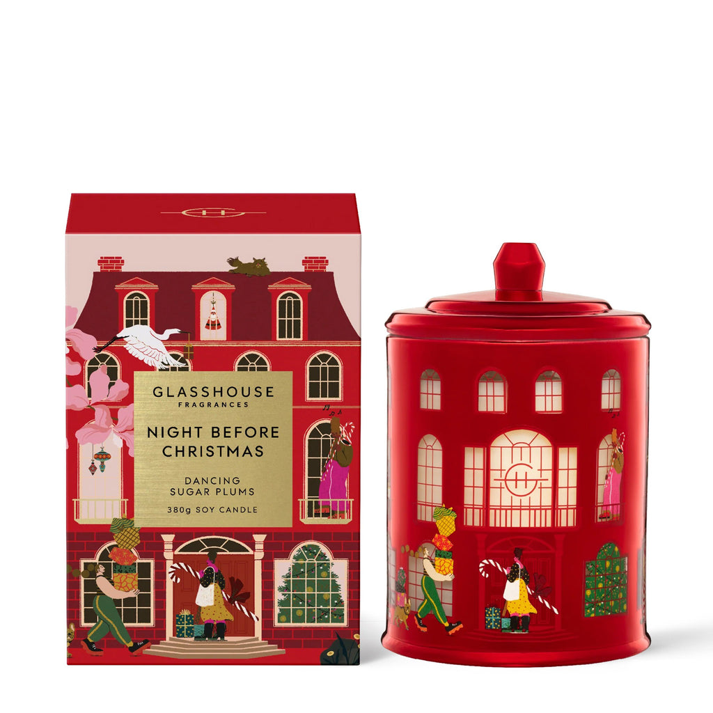 Glasshouse Fragrances Night Before Christmas Dancing Sugar Plums scented soy wax candle in house illustrated red glass jar with lid beside matching red and pink house gift box, front view.