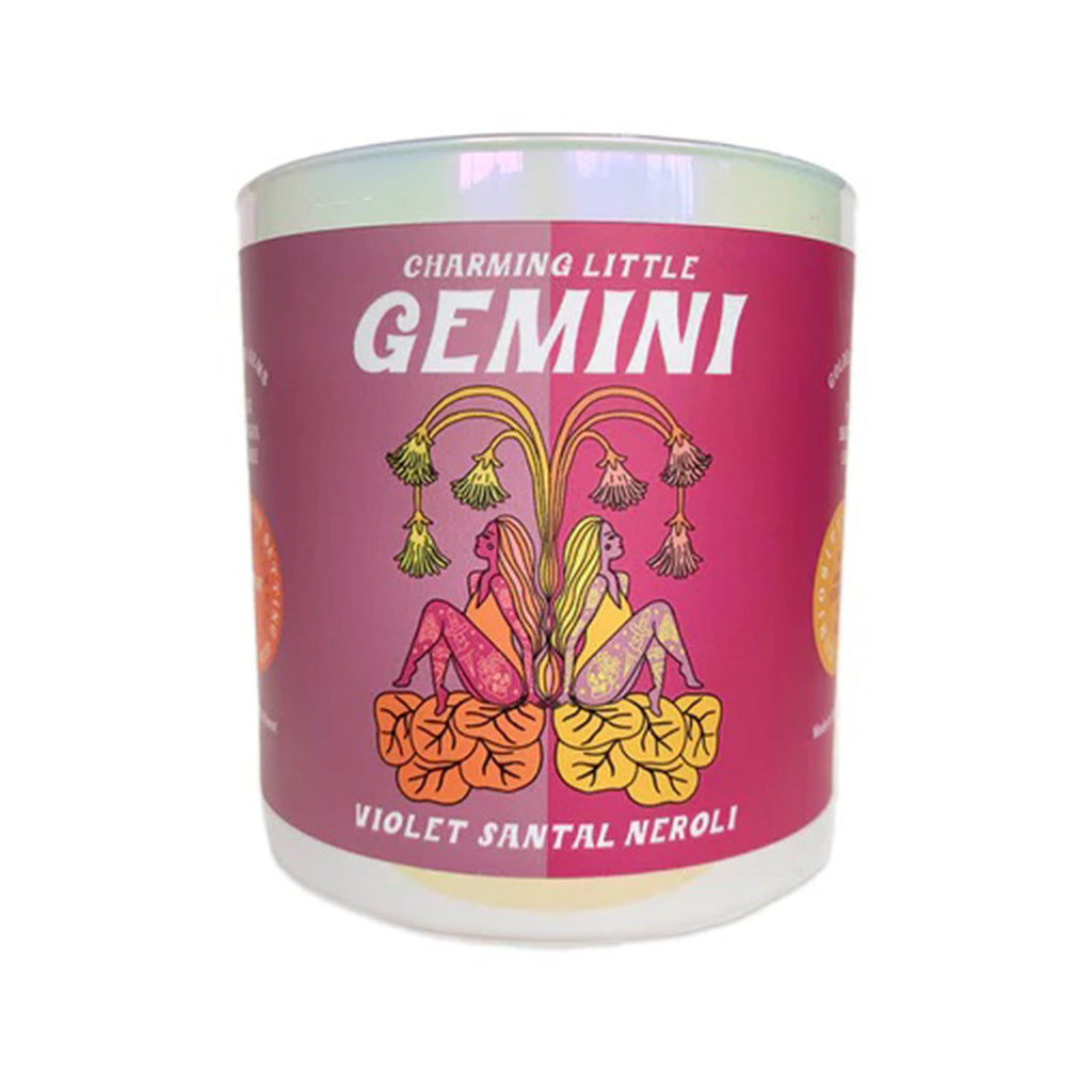 Golden Gems Charming Little Gemini Violet Santal Neroli scented soy wax candle with illustrated mauve and fuchsia label on an iridescent white glass tumbler, front view.