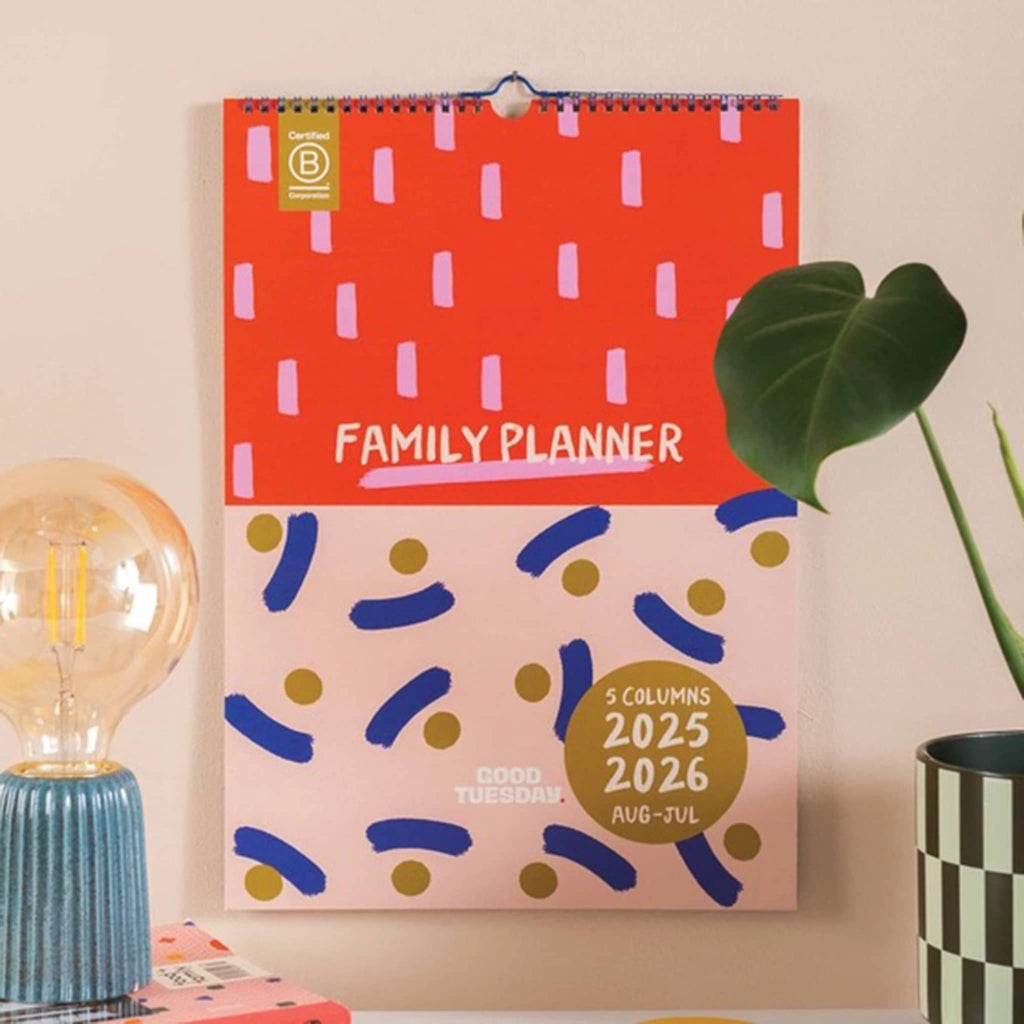 Family planner wall calendar front cover, hanging on a wall.